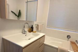 un bagno bianco con lavandino e vasca di Coastal Courtyard Retreat Jasmine Hideaway Sunshine Coast a Kawana Waters Altre 20 foto