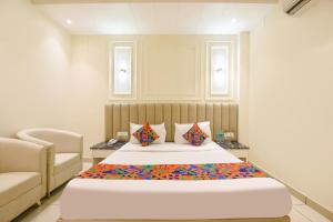 a bedroom with a large bed and a couch at FabHotel Dev Palace I - Pitampura in New Delhi