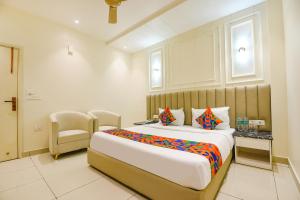 a hotel room with a large bed and a chair at FabHotel Dev Palace I - Pitampura in New Delhi +18 photos