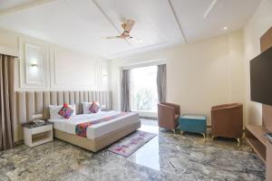 a hotel room with a bed and a window at FabHotel Dev Palace I - Pitampura in New Delhi