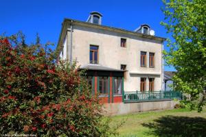 an old house on a hill with red flowers at Chambre Coton, Au Fil du Temps in Fougerolles