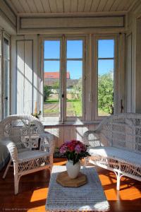 a room with chairs and a table with a vase of flowers at Chambre Coton, Au Fil du Temps in Fougerolles