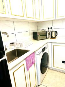 una cocina con fregadero y lavadora en Bintang Suites At Axon Residence KL, en Kuala Lumpur