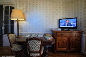 a living room with a table with a television on it at Chambre Coton, Au Fil du Temps in Fougerolles