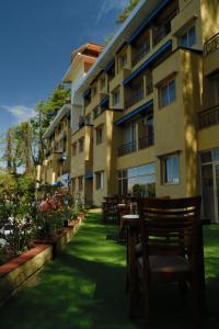 eine Reihe von Stühlen vor einem Gebäude in der Unterkunft Shimla Golf Resorts in Shimla