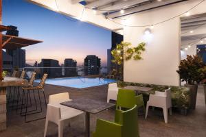 卡塔赫纳卡塔赫纳希尔顿汉普顿酒店的一个带桌椅的屋顶露台,享有城市美景