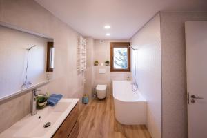 a bathroom with a large white tub and a sink at Rural apartment La Cantonada in Guardiola de Berguedà +16 photos