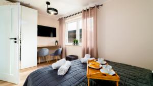 a bedroom with a bed and a table with food on it at Apartamenty Wonder Home z pięknymi widokami na góry, blisko terenów spacerowych i szlaków in Karpacz