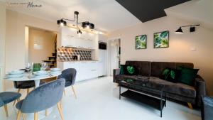 a living room with a couch and a table at Apartamenty Wonder Home z pięknymi widokami na góry, blisko terenów spacerowych i szlaków in Karpacz