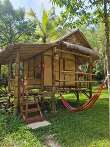 a small hut with a hammock in the grass at Koh kood Good Time by Jasmine in Ko Kood