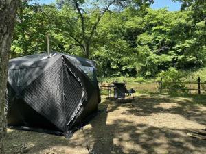 a tv sitting next to a tree in a field at 秋保木の家ロッジ村 in Sendai