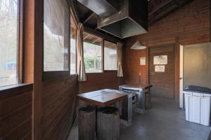 a kitchen with a table and a stove in a cabin at 秋保木の家ロッジ村 in Sendai
