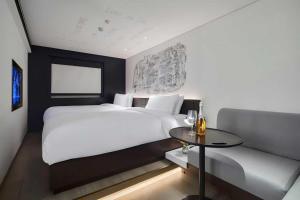 a bedroom with a bed and a table and a couch at CitiGO Hotel, South Gate of Xi'an Bell Tower in Xi'an