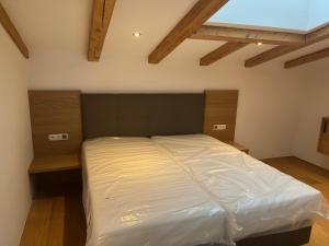 a large bed in a room with wooden ceilings at Panorama Quartier Seefeld in Seefeld in Tirol