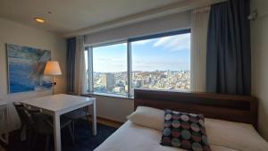 a hotel room with a bed and a desk and a window at Paradise Hongdae in Seoul