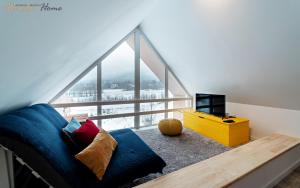 a living room with a blue couch in front of a window at Apartamenty Wonder Home z pięknymi widokami na góry, blisko terenów spacerowych i szlaków in Karpacz