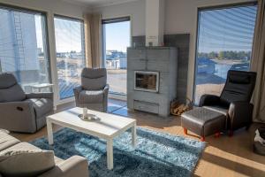 un soggiorno con camino, sedie e tavolo di Aurinkorinne 8 a Kalajoki