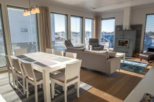 un soggiorno con tavolo, sedie e divano di Aurinkorinne 8 a Kalajoki