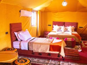 a bedroom with two beds in a yellow room at Andromeda Desert Astro Camp in Tisserdmine