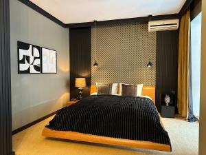a bedroom with a large bed with black sheets at Relax in Style Boutique Hotel in Braşov