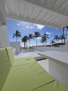 a room with a view of the beach and palm trees at Bungalows Villas Blancas in Puerto del Carmen