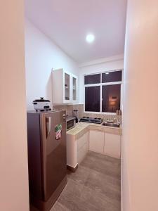 a small kitchen with a stainless steel refrigerator at Urban Oasis Residence in Nugegoda