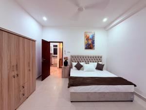 a bedroom with a large bed and a painting on the wall at Urban Oasis Residence in Nugegoda