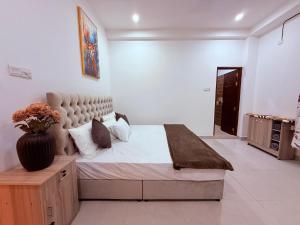 a bedroom with a bed and a vase on a table at Urban Oasis Residence in Nugegoda