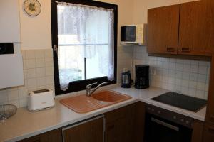 Ferienhaus Nr 125, Kategorie Economy, Feriendorf Hochbergle, Allgäu في Karlsebene: طاولة مطبخ مع حوض ونافذة +10 صور