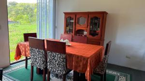 ein Esszimmer mit einem Tisch und Stühlen sowie einem Schrank in der Unterkunft Habitación doble # 3 in Macas