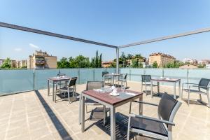 a patio with tables and chairs on a roof at Eurostars Executive in Barbera del Valles