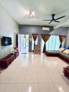 a living room with a couch and a ceiling fan at Animation Homes I Meru Raya IPOH I by Grab A Stay l 16pax max in Ipoh +25 photos
