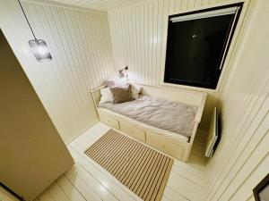 Una cama pequeña en una habitación con ventana. en Charming Cottage Near Heatherhill With SPA - Rågeleje, en Rågeleje