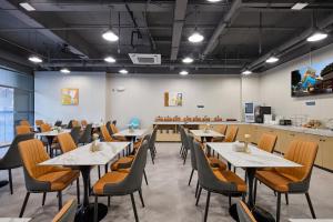 ein Restaurant mit Tischen und Stühlen in einem Raum in der Unterkunft Urbain S Hotel, Xiamen Railway Station Mingfa Commercial Plaza in Xiamen + 52 Fotos