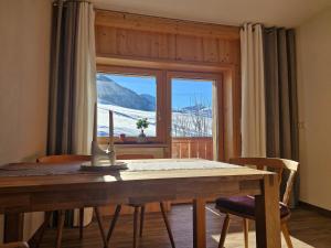 ein Esstisch mit Blick auf einen schneebedeckten Berg in der Unterkunft Neunerköpfle in Tannheim