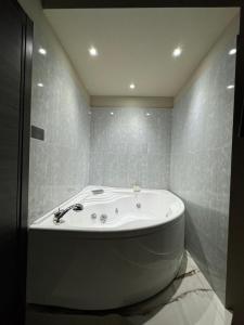 a white bath tub in a bathroom with tiles at Dimora Sovrana in Laurignano