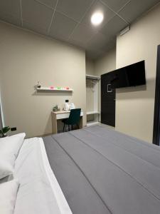 a room with a bed and a desk with a television at Dimora Sovrana in Laurignano