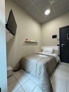 a bedroom with a bed and a tv on the wall at Dimora Sovrana in Laurignano