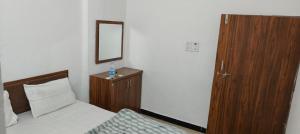 Un dormitorio con una cama, una cómoda y un espejo. en Hotel Trilochan, en Sehore