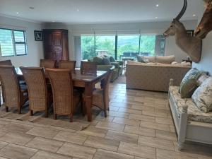 a living room with a table and chairs at Carshalton Cottage in Mooirivier