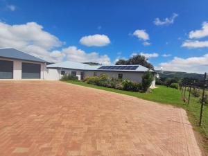 a house with a driveway with solar panels on it at Carshalton Cottage in Mooirivier