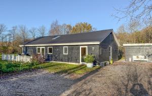a small house with a black roof at Beautiful Home In Oksbøl With Sauna in Øster Vrøgum