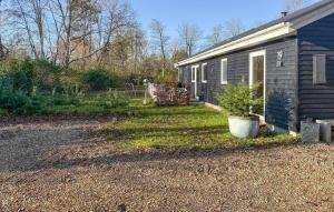 a yard next to a house with a potted plant at Beautiful Home In Oksbøl With Sauna in Øster Vrøgum