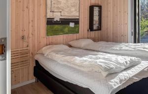two beds in a room with wooden walls at Beautiful Home In Oksbøl With Sauna in Øster Vrøgum