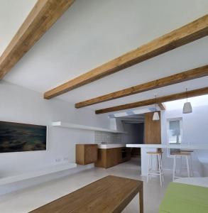 una cucina e un soggiorno con pareti bianche e travi in legno di Bungalows Villas Blancas a Puerto del Carmen