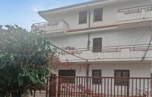 een wit huis met een hek ervoor bij Pet Friendly Apartment In Briatico in Pannaconi