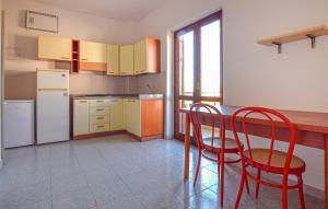 een keuken met een tafel en twee rode stoelen bij Pet Friendly Apartment In Briatico in Pannaconi