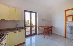 een keuken met een tafel en stoelen en een raam bij Pet Friendly Apartment In Briatico in Pannaconi