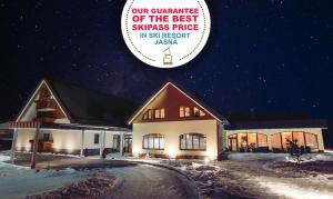 a building with a sign that reads our guarantee of the best swiss price in at Wellness Hotel Demänová in Liptovský Mikuláš