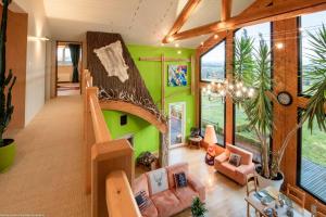 a living room with a green wall and a staircase at Chambre Rambouillet, Au Domaine du Cerf in Vyans